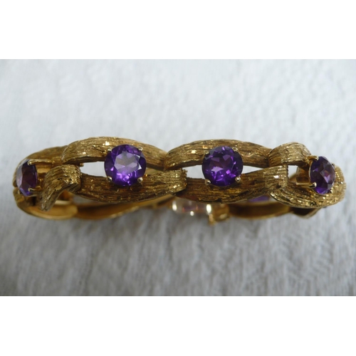 371 - A good 18 ct. gold amethyst bracelet with bark finish and 15 cts. of amethysts each dtone diam 8mm -... 