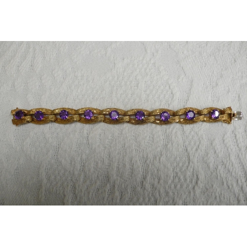 371 - A good 18 ct. gold amethyst bracelet with bark finish and 15 cts. of amethysts each dtone diam 8mm -... 