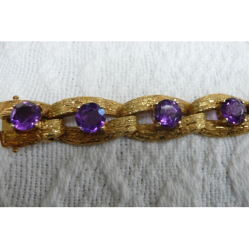 371 - A good 18 ct. gold amethyst bracelet with bark finish and 15 cts. of amethysts each dtone diam 8mm -... 