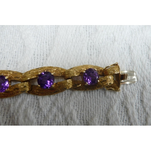 371 - A good 18 ct. gold amethyst bracelet with bark finish and 15 cts. of amethysts each dtone diam 8mm -... 