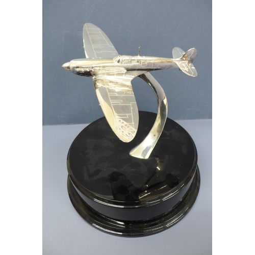 38 - A silver model of a spitfire in flight. Mounted on a black enamel circular plaque diameter 10ins, Wi... 