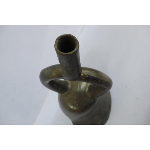 131 - An Early/Middle period blackware pottery Stirrup Vessel in the form of a mans head wearing a headdre... 