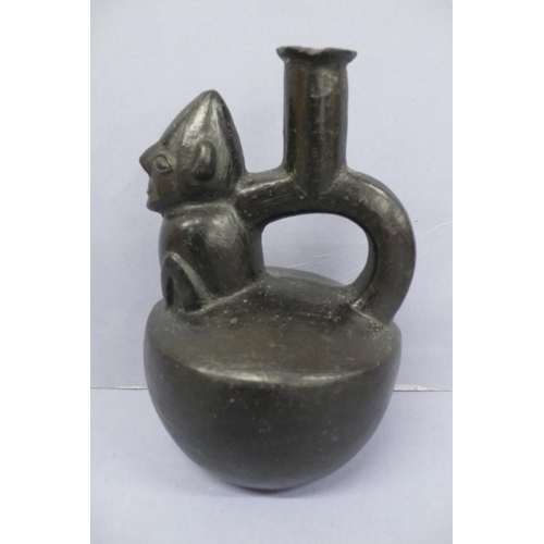 134 - A Vicus Blackware Pottery Effigy Stirrup Handle Vessel in the form of a restrained man in a conical ... 
