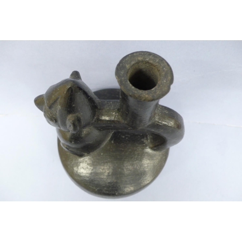 134 - A Vicus Blackware Pottery Effigy Stirrup Handle Vessel in the form of a restrained man in a conical ... 
