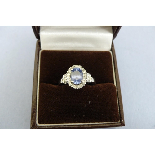 174 - A Platinum Ring set with oval Ceylon Sapphire surrounded by baguette cut diamonds, Size L/M