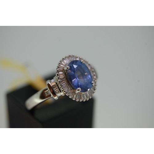 174 - A Platinum Ring set with oval Ceylon Sapphire surrounded by baguette cut diamonds, Size L/M