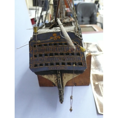 138 - A Victorian wooden model of H.M.S. Victory (some damage), length 20ins plus six postcards