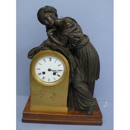 139 - A 19thC French mantel clock with bronze figure of a woman leaning on an ormolu clock with white enam... 