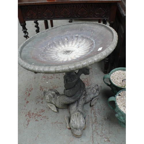 176 - A lead bird bath in the form of three dolphins with twisted tails holding a circular fluted dish abo... 