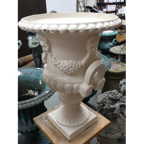 204 - A pair of cast iron two handled fluted urns with mask decoration - height 24 ins approx