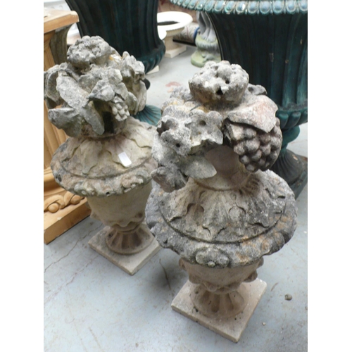 206 - A pair of carved Portland stone urns with floral finials - height 29 ins approx