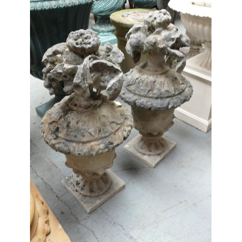 206 - A pair of carved Portland stone urns with floral finials - height 29 ins approx