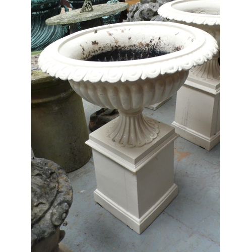 207 - A pair of cast iron fluted campana urns on square pedestals - height 28 ins approx, diameter 21 ins ... 