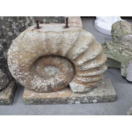 220 - A garden rectangular table made from limestone with carved amonite pedestal bases, 25x34x21ins