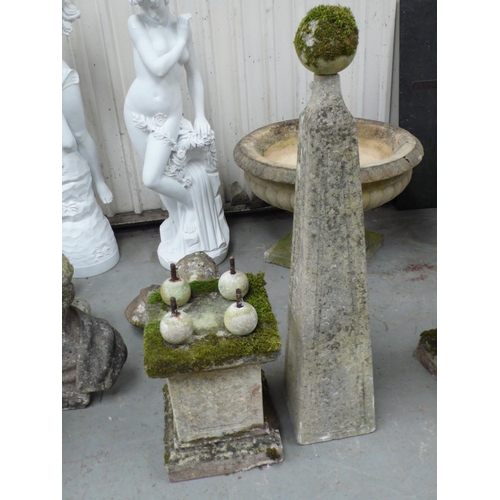 221 - A pair of carved stone obelisks with ball finials, square tapering column, four ball supports on ste... 