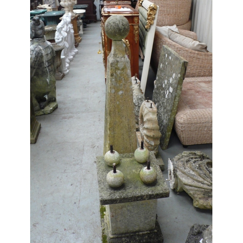 221 - A pair of carved stone obelisks with ball finials, square tapering column, four ball supports on ste... 