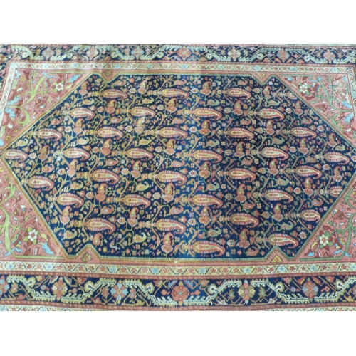 235 - A 19th/20thC Middle Eastern handmade wool carpet with floral decoration in multicoloured wools on a ... 