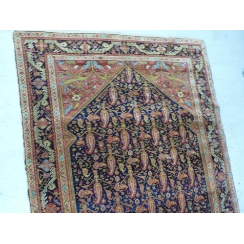 235 - A 19th/20thC Middle Eastern handmade wool carpet with floral decoration in multicoloured wools on a ... 