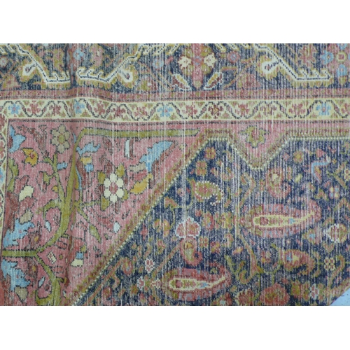 235 - A 19th/20thC Middle Eastern handmade wool carpet with floral decoration in multicoloured wools on a ... 