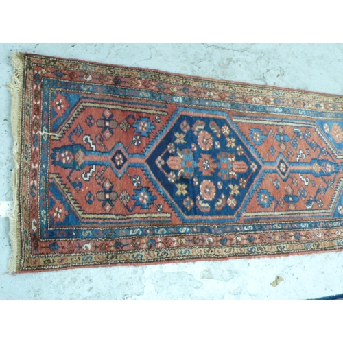 239 - Middle Eastern handmade wool runner with geometric designs in mainly red and blue wool, 113x29ins