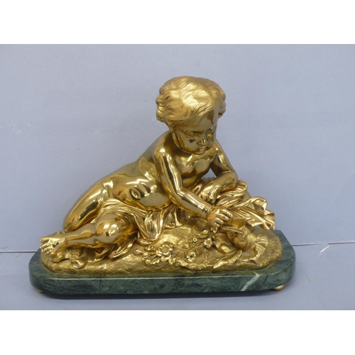 24 - An Ormolu figure of an infant touching a butterfly on a green figured marble base, height 9.75ins