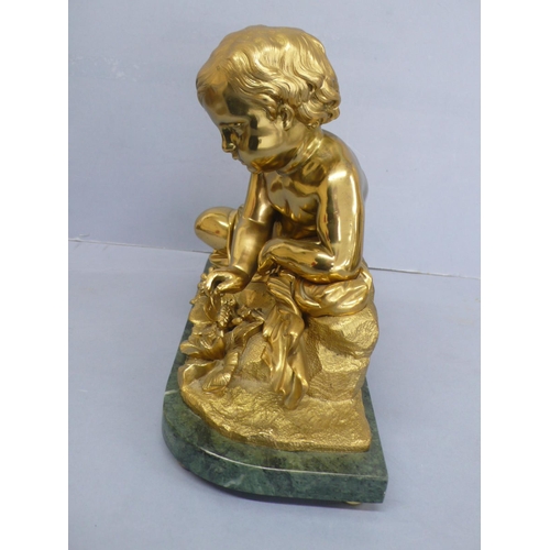 24 - An Ormolu figure of an infant touching a butterfly on a green figured marble base, height 9.75ins