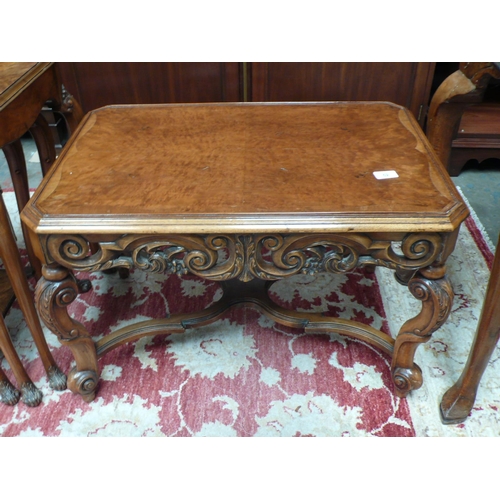 52 - A walnut carved occasional table with X stretcher on carved cabriole legs - width 28 ins approx