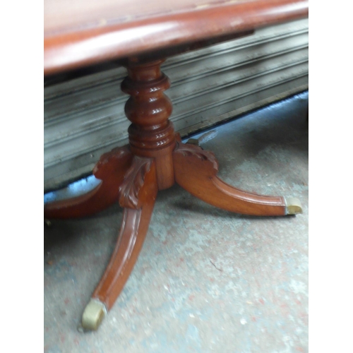 62 - A Victorian mahogany drop leaf tea table with turned column and sabre legs and brass castor extensio... 