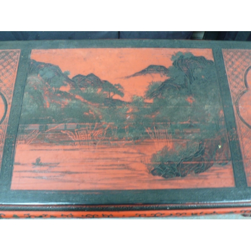 64 - A Chinese red and black painted side table with decoration of lakes, flowers, vases, birds on shaped... 