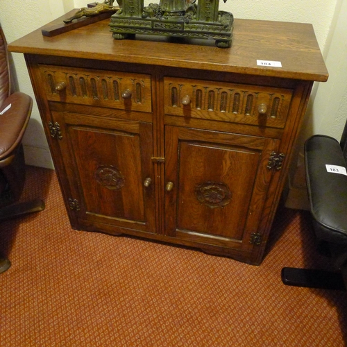 184 - A reproduction carved oak cabinet with 2 drawers and 2 doors (located in room 51)