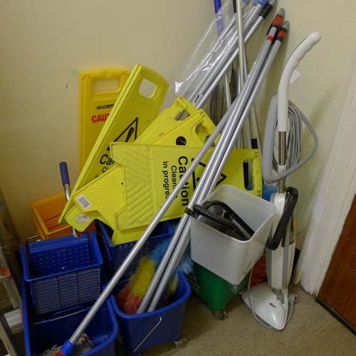 295 - A quantity of various cleaning items including an electric steam mop other mop handles cleaning sign... 