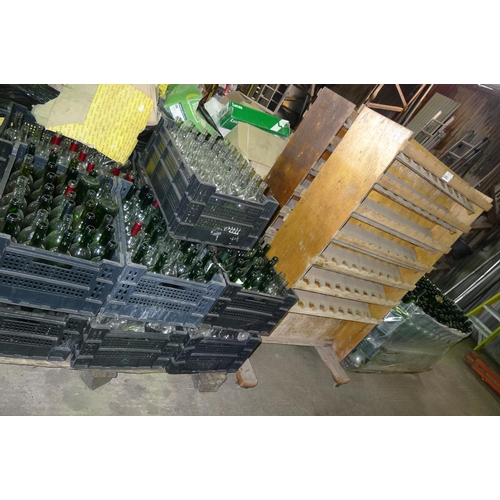 2062 - 2 wooden mobile bottle racks and 2 pallets containing a large quantity of various glass wine bottles