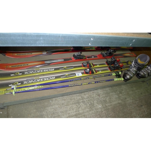 86 - 2 pairs of skis, 1 pair of poles and 1 pair of ski boots. Contents of one shelf