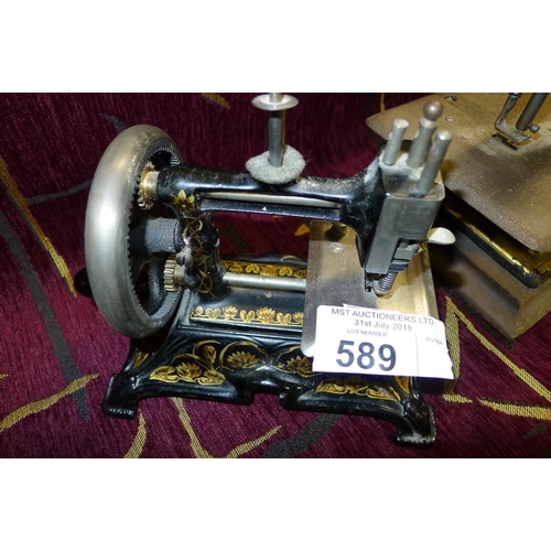 589 - A miniature decorative antique hand cranked sewing machine