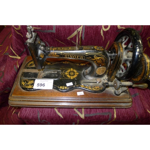 596 - A decorative antique hand cranked Singer sewing machine with a fiddle base, no cover