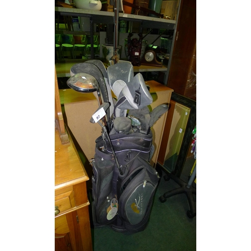 97 - 1 golf bag containing various golf clubs