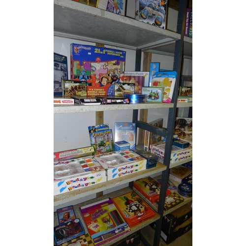 312 - A quantity of various children's toys puzzles etc, contents of four shelves