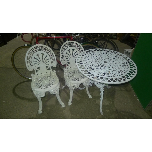 63 - 1 white cast metal garden table with 2 chairs - table support is cracked and requires attention