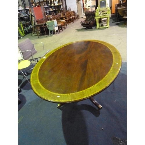 1095 - 1 regency style mahogany oval tipping top pedestal table with splayed legs and a satin wood cross ba... 