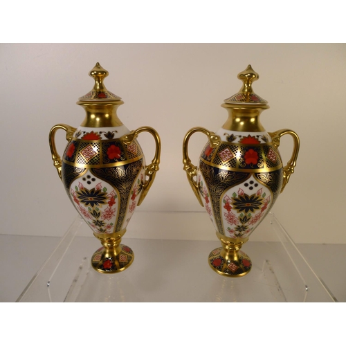 337 - A pair of Royal Crown Derby old Imari 1128, 2 handled Tissington vases with covers 20cm tall. With b... 