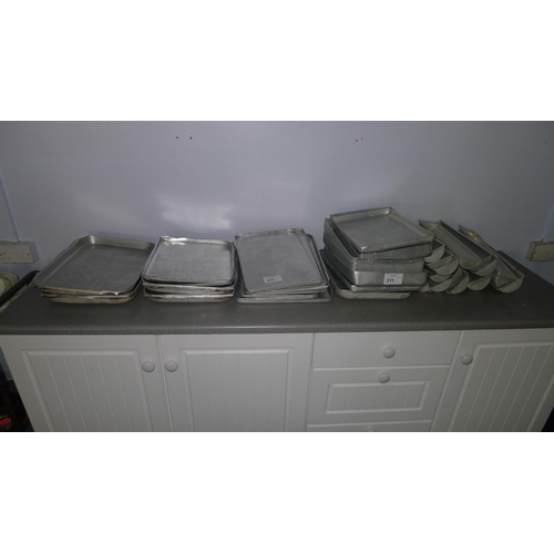 311 - A quantity of metal trays and two part aluminium pudding sleeves 38cm