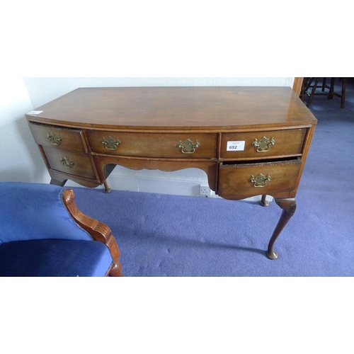 692 - A bow front walnut writing table with 5 drawers