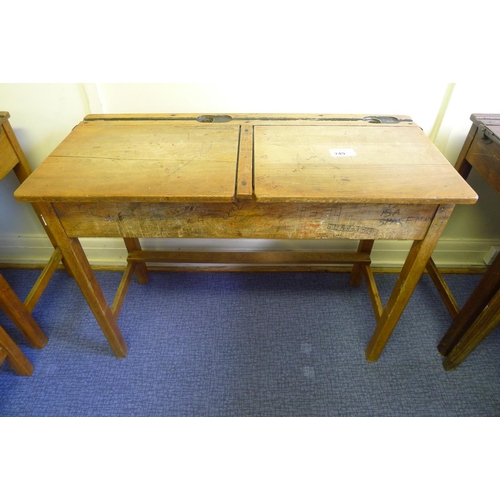 749 - A vintage wooden double classroom desk with lift lids