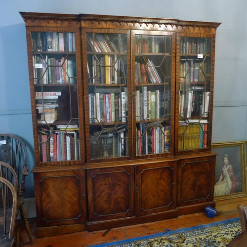 829 - A reproduction mahogany breakfront bookcase with glazed doors above and panelled doors below, approx... 