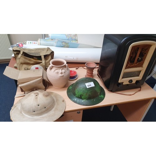 609 - A vintage Bakelite cased mains radio, a World War II metal helmet, a pith helmet,  and various other... 