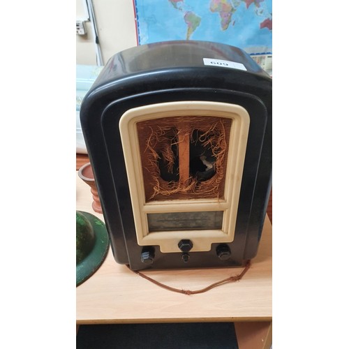 609 - A vintage Bakelite cased mains radio, a World War II metal helmet, a pith helmet,  and various other... 