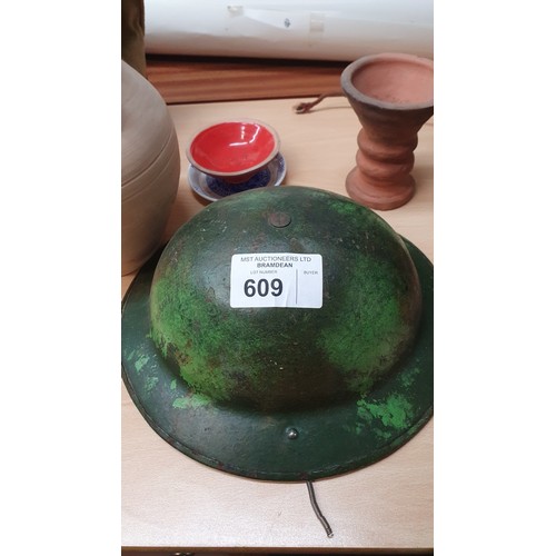 609 - A vintage Bakelite cased mains radio, a World War II metal helmet, a pith helmet,  and various other... 