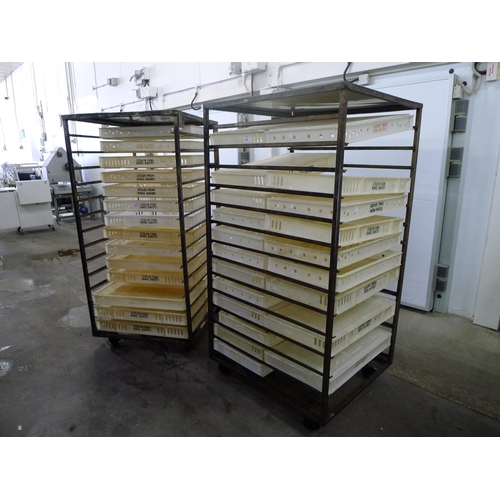 101 - 2 metal wheeled racks containing a quantity of plastic trays