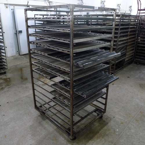 194 - 1 metal wheeled bakers rack containing a quantity of metal trays