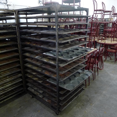 195 - 1 metal wheeled bakers rack containing a quantity of metal trays